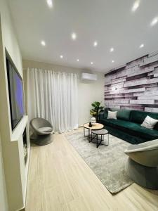 un soggiorno con divano verde e TV di CASA MILITOU-NEA FILADELFIA ad Atene