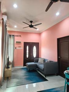 a living room with a couch and a ceiling fan at NazLa Homestay Pendang in Pendang