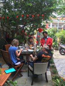 een groep mensen die rond een tafel zitten bij Cherry Garden Homestay in Hội An