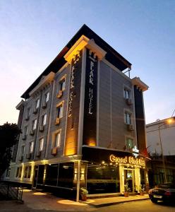 un gran edificio con un cartel en la parte delantera en Grand Black Hotel, en Mersin