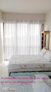 1 Schlafzimmer mit 2 Betten und einem Fenster mit Vorhängen in der Unterkunft Taal Lake Staycation Juliet's Vacation in Splendido Free Parking Netflix in Tagaytay