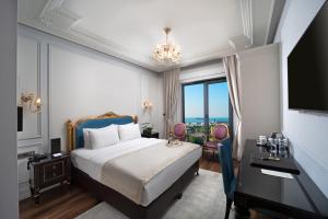 Dormitorio con cama, escritorio y TV en The Time Hotel Marina, en Estambul