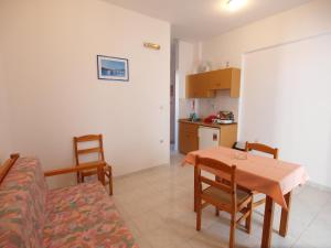 a living room with a table and chairs and a kitchen at Irini Apartments in Platanias