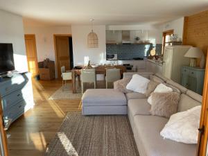 uma sala de estar com um sofá e uma cozinha em Apartment with stunning view! Ski-in, ski-out em Villars-sur-Ollon