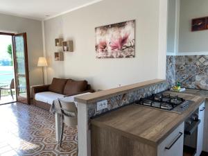 eine Küche mit einem Herd und ein Wohnzimmer mit einem Sofa in der Unterkunft Villa Soghetta Typ S4 in Crone