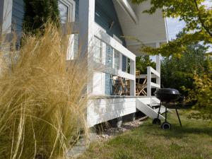 a barbecue grill sitting outside of a house at By The Sea Lodges in Wrzosowo