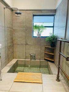 baño con bañera con ventana y plantas en NEW! Luxury 1 bed garden apartment Camden Town, en Londres