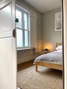 1 dormitorio con cama y ventana en NEW! Luxury 1 bed garden apartment Camden Town, en Londres
