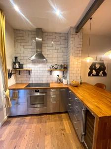 cocina con electrodomésticos de acero inoxidable y suelo de madera en NEW! Luxury 1 bed garden apartment Camden Town, en Londres
