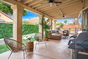 eine Terrasse mit Stühlen und einem Deckenventilator in der Unterkunft Golden Desert Getaway Family Friendly Home in Indio