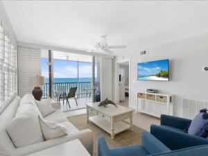una sala de estar con muebles blancos y vistas al océano. en Estero Island Beach Villas 601, 2 Bedrooms, Beach Front, WiFi, Sleeps 6, en Fort Myers Beach