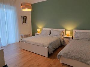 1 dormitorio con 2 camas y 2 lámparas. en B&B Tanto Piacere Taranto, en Taranto
