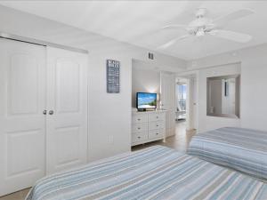 1 dormitorio blanco con 1 cama y ventilador de techo en Estero Island Beach Villas 601, 2 Bedrooms, Beach Front, WiFi, Sleeps 6, en Fort Myers Beach