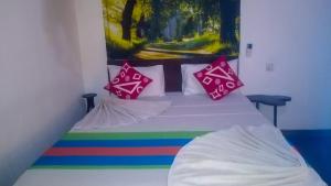a bed with colorful pillows and a rainbow at Gangula Eco lodge in Sigiriya