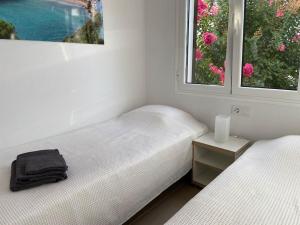 two twin beds in a room with two windows at Modernes Apartment mit traumhaftem Blick Vistamar3 in Cala'n Porter +26 photos