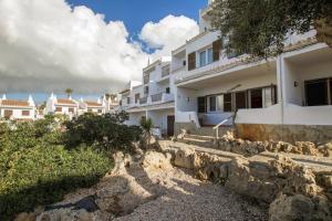a large white building with stairs in front of it at Modernes Apartment mit traumhaftem Blick Vistamar3 in Cala'n Porter