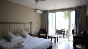Habitación de hotel con cama y balcón en Margate Hotel en Margate