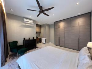a bedroom with a white bed and a ceiling fan at Msplus in Jenjarum +7 photos