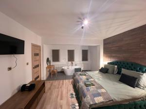 ein Schlafzimmer mit einem Bett und ein Badezimmer mit einer Badewanne in der Unterkunft Green Home in Miercurea Ciuc