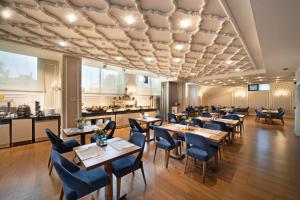 un restaurante con mesas y sillas de madera y una cocina en The Time Hotel Marina en Estambul