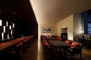 a restaurant with tables and chairs and a bar at Sheraton Grand Hiroshima Hotel in Hiroshima