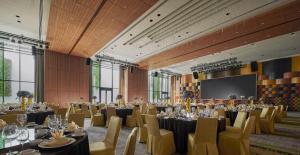a banquet hall with tables and chairs and a screen at PARKROYAL Langkawi Resort in Pantai Cenang +37 photos