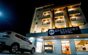 un coche aparcado frente a un hotel luminoso en Spotlight Hotel en Alaminos