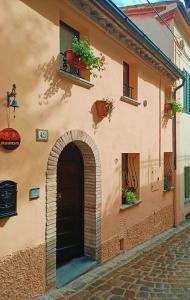 a building with an archway and flower boxes on it at B&B Brunamonti in Arcevia