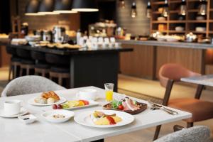 a white table with plates of food on it at Sheraton Grand Hiroshima Hotel in Hiroshima