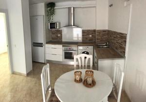 une cuisine avec une table et des chaises dans l'établissement Apartamento SalouMar, à Salou