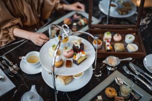 a plate of food on a table with tea and desserts at Sheraton Grand Hiroshima Hotel in Hiroshima