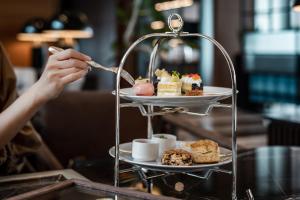 a person is eating food on a dessert stand at Sheraton Grand Hiroshima Hotel in Hiroshima