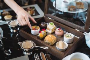 a person is reaching for a tray of desserts at Sheraton Grand Hiroshima Hotel in Hiroshima