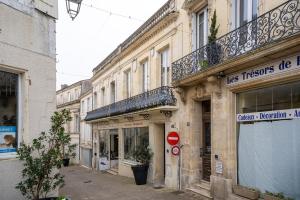 Una calle con un edificio con un cartel. en Les Jardins De La Seugne, en Jonzac