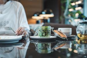 a person is holding a table with a jar of food at Sheraton Grand Hiroshima Hotel in Hiroshima