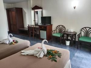 a hotel room with two beds with swans on them at Ban Nam Mao Resort in Na Jomtien