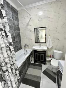 een badkamer met een bad, een toilet en een wastafel bij Квартира ЖК Apple city in Astana