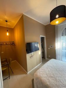 een slaapkamer met een bed en een flatscreen-tv bij Angolo di isa in Busto Arsizio