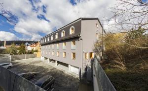 a white building with a fence in front of it at Hotel Herrmes in Prague