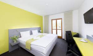 1 dormitorio con 1 cama, escritorio y TV en Hotel Herrmes, en Praga