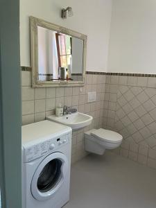 a bathroom with a washing machine and a sink at Zaciszne Apartamenty in Poddąbie