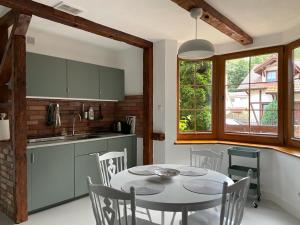 a kitchen and dining room with a table and chairs at Zaciszne Apartamenty in Poddąbie