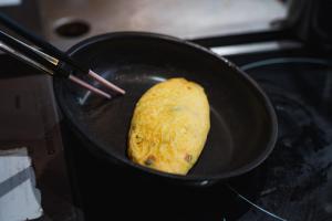 a tortilla is being fried in a pan on the stove at Sheraton Grand Hiroshima Hotel in Hiroshima