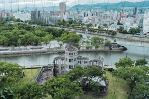 a building with a clock tower in the middle of a city at Sheraton Grand Hiroshima Hotel in Hiroshima