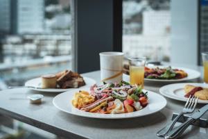 a table topped with plates of food and drinks at Sheraton Grand Hiroshima Hotel in Hiroshima