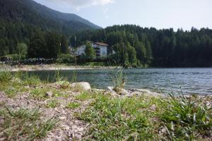 una casa sentada en la orilla de un lago en Hotel Pineta, en Baselga di Pinè