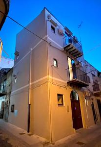 a white building with a balcony on a street at LB Home in Termini Imerese