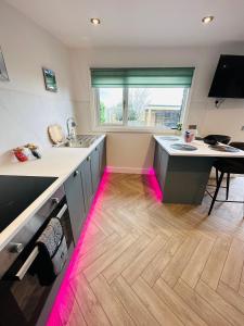 uma cozinha com luzes cor-de-rosa no chão em Hazells Lodge Farm Stay Sleeps 2 Hottub Pool Table at Ayrshire Rural Retreats em Galston