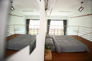 2 Betten in einem großen Zimmer mit Fenstern in der Unterkunft Private 100 inches Screen Cinema at CEO Penang in Bayan Lepas