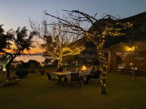 un grupo de personas sentadas en una mesa con luces en Klovino beach house, en Douviá